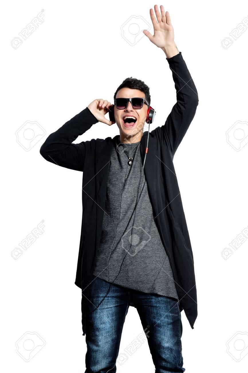 音楽を聴きながら彼の手を上げるヘッドフォンで魅力的な男性 白を分離します の写真素材 画像素材 Image