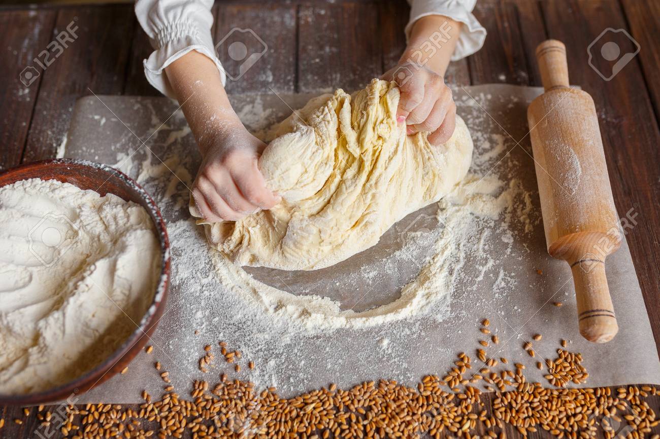 Detail of hands kneading dough on wooden table - 95852302 Detail of hands kneading dough on wooden table - 95852302