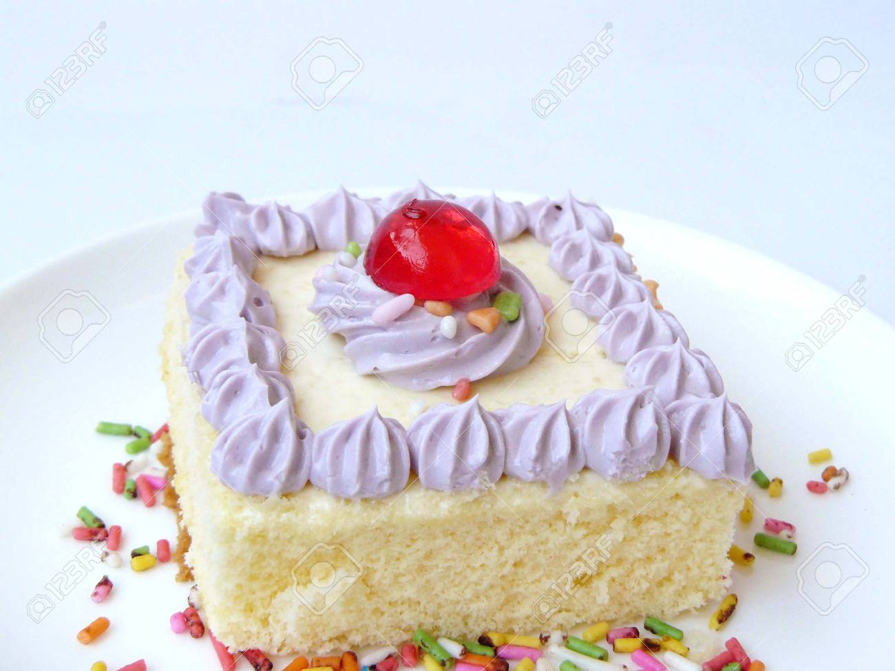 Gateau Creme A La Vanille Violet Le Gateau A La Vanille Decore De Creme Douce Violette De Sucre Et De Boule De Gelee Rouge Sur Une Plaque Blanche Avec Une Fourchette En