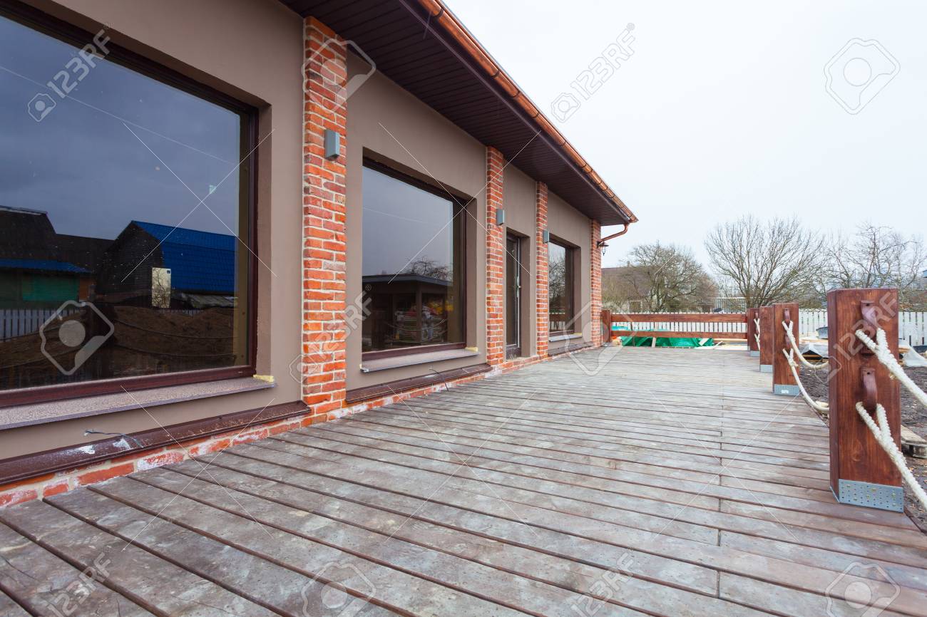 Das Moderne Haus Mit Grossen Fenstern Und Mit Breiter Holzterrasse