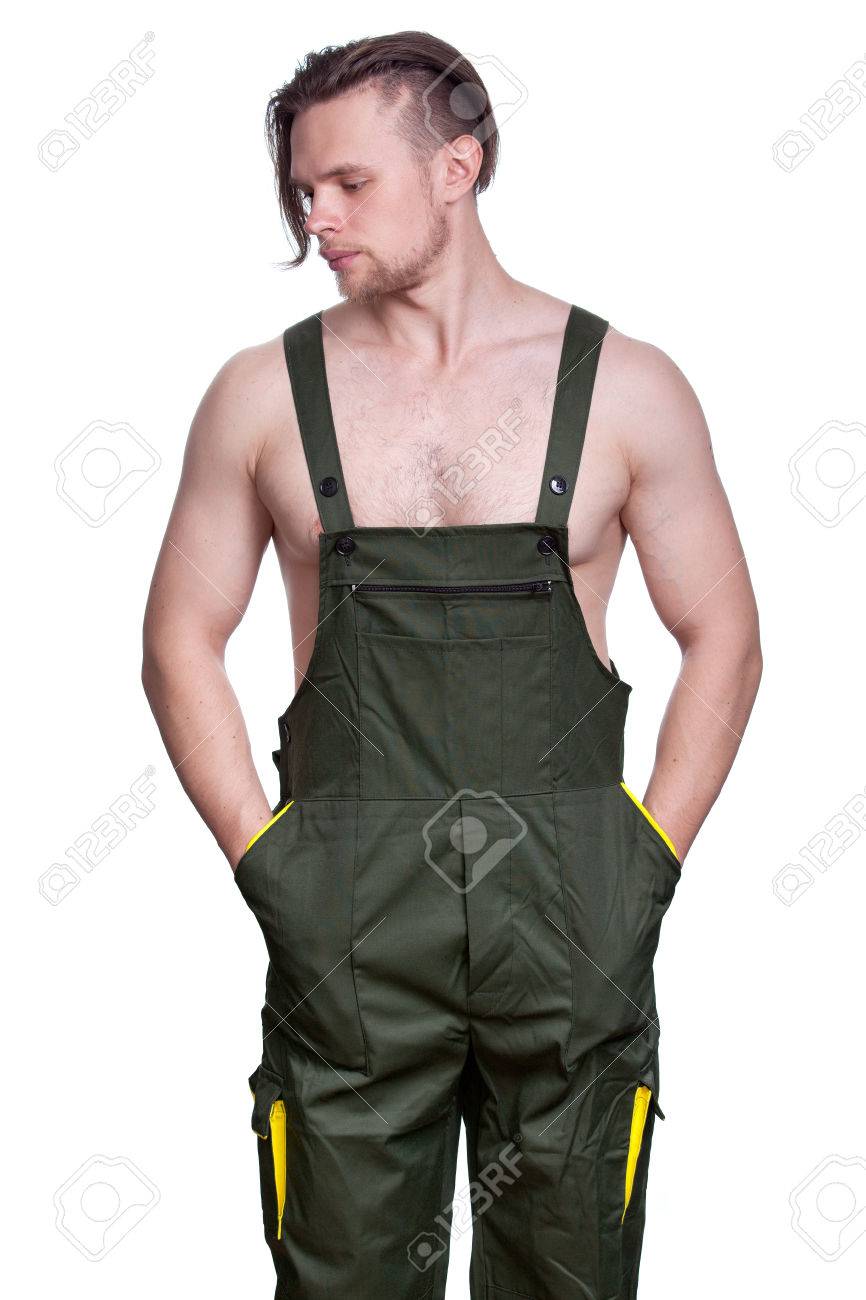 Hombre Fuerte Joven Con El Torso Desnudo En Un Uniforme De Trabajo Se Metió  Las Manos En Los Bolsillos. La Imagen Sobre Un Fondo Blanco. Fotos,  retratos, imágenes y fotografía de archivo