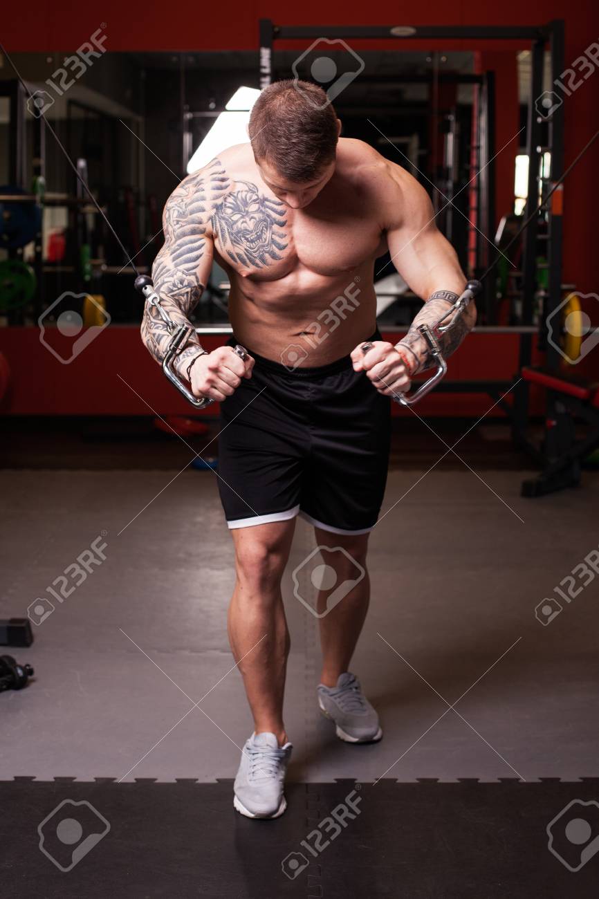 ジムで胸筋のクロス オーバーの運動を実行する 裸の胴体を持つボディービルダー男 の写真素材 画像素材 Image