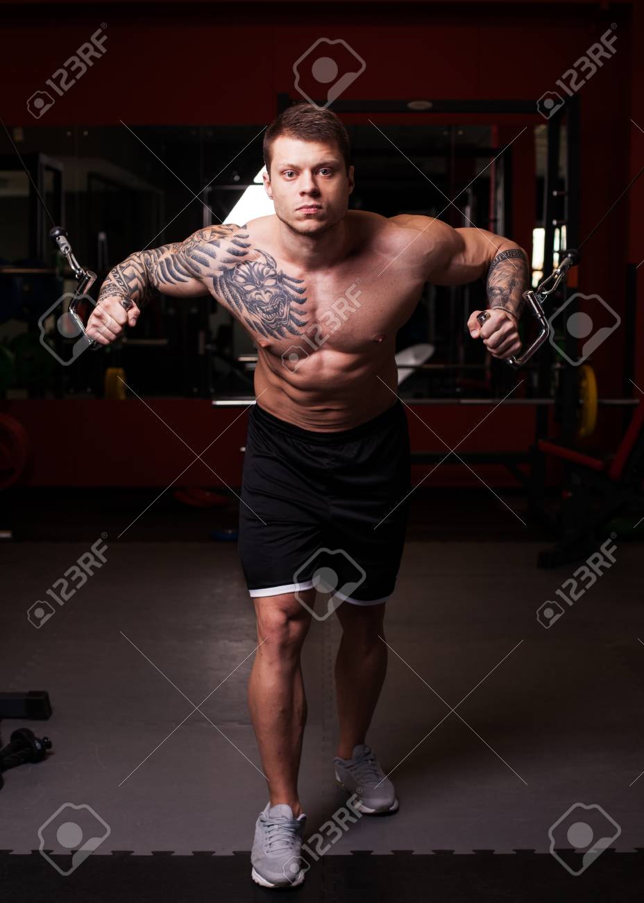 ジムで胸筋のクロス オーバーの運動を実行する 裸の胴体を持つボディービルダー男 の写真素材 画像素材 Image