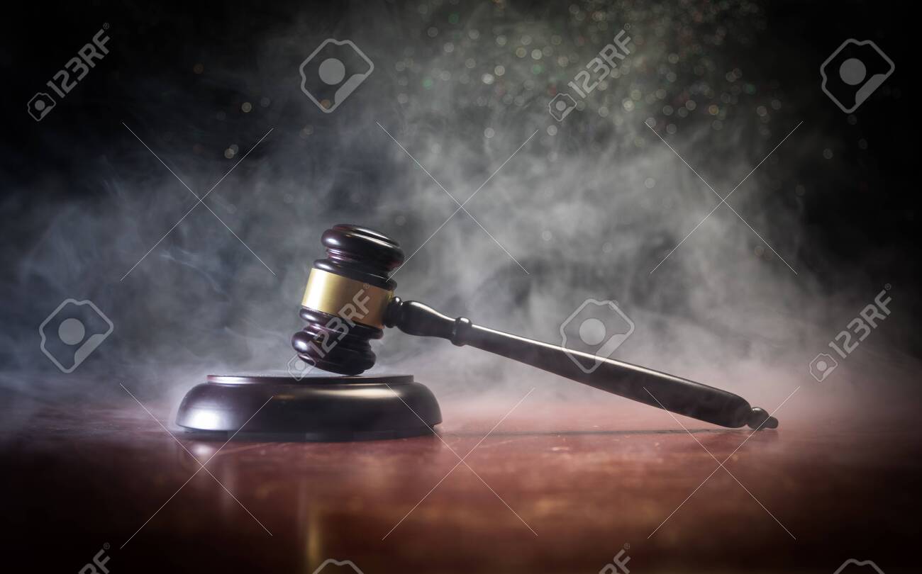 Law theme, mallet of the judge on wooden desk with Lady Justice Statue. Law gavel on dark foggy background with light. Selective focus - 120671196 Law theme, mallet of the judge on wooden desk with Lady Justice Statue. Law gavel on dark foggy background with light. Selective focus - 120671196