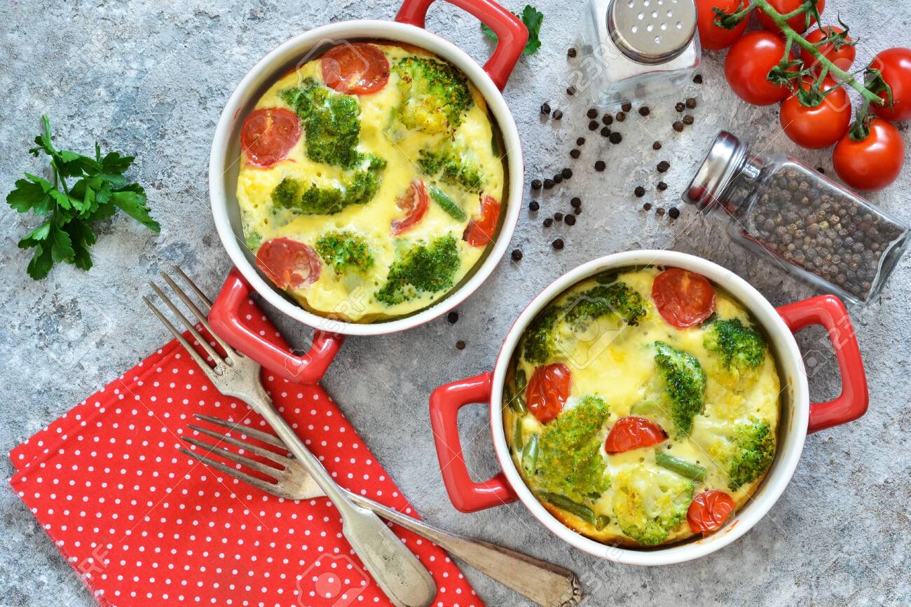 Casserole with broccoli and tomatoes on a concrete background. View from above. - 121015143 Casserole with broccoli and tomatoes on a concrete background. View from above. - 121015143