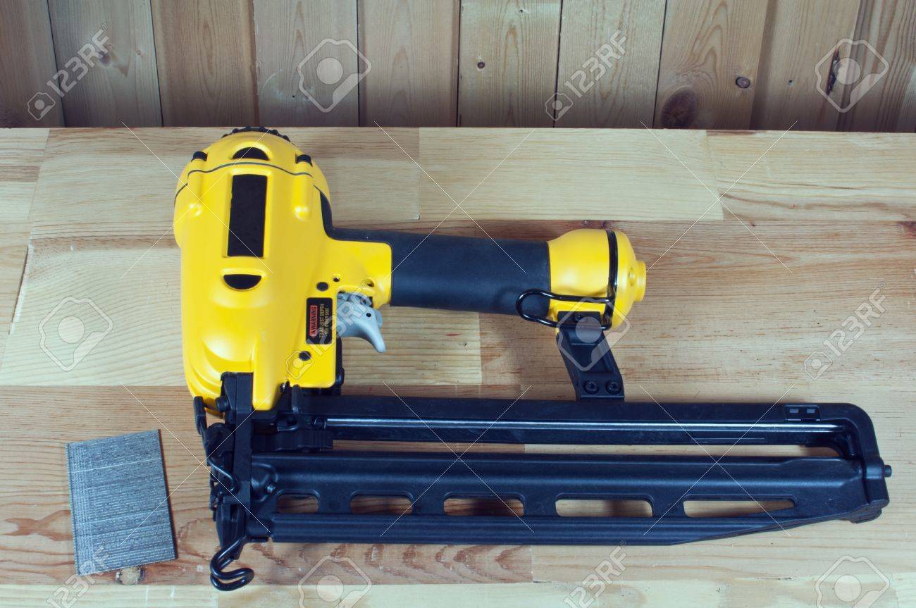 Nail Gun And Nails On Wood Background Stock Photo Picture And