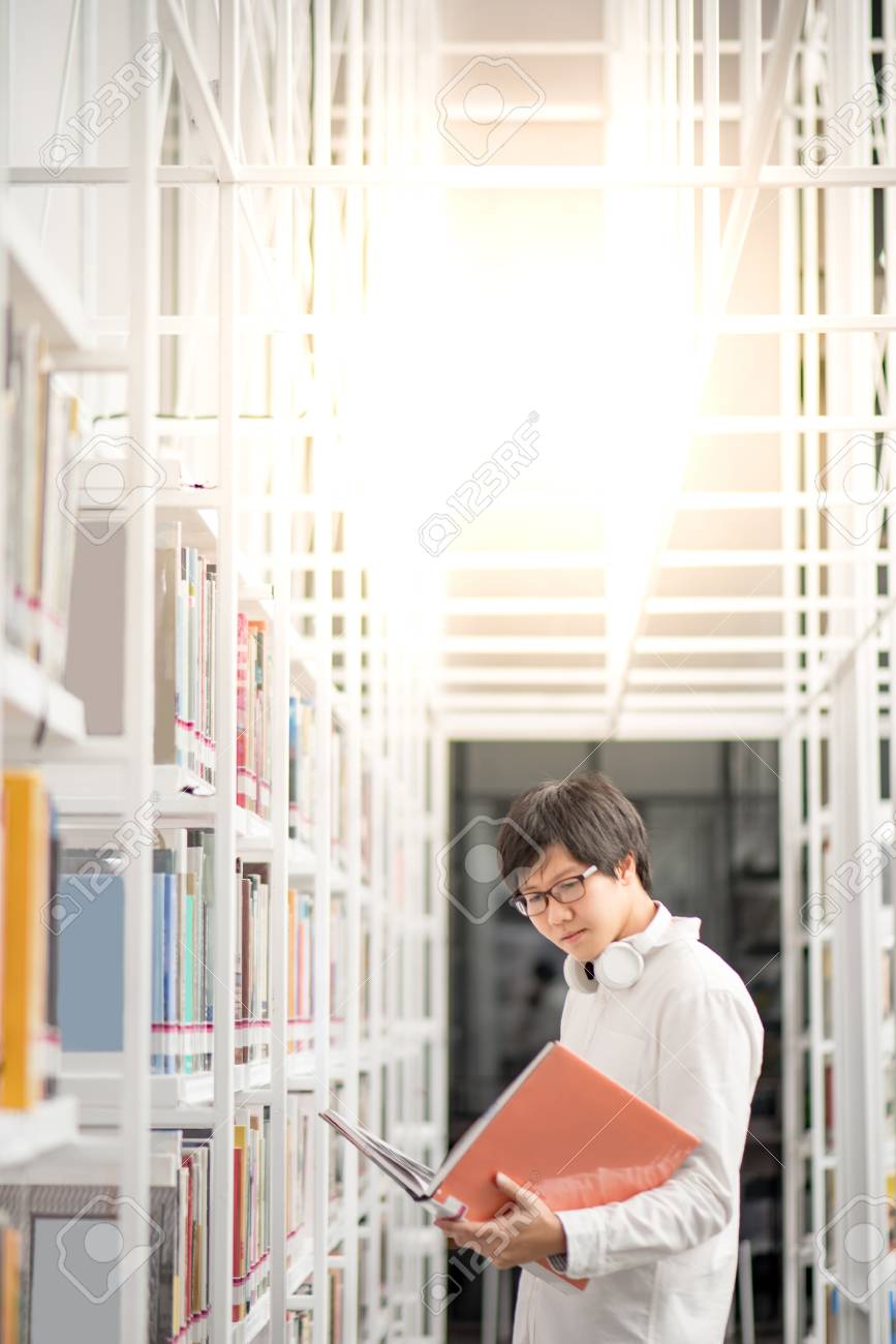 Young Asian man university student reading book in library, education research and self learning in university life concepts - 96241732 Young Asian man university student reading book in library, education research and self learning in university life concepts - 96241732