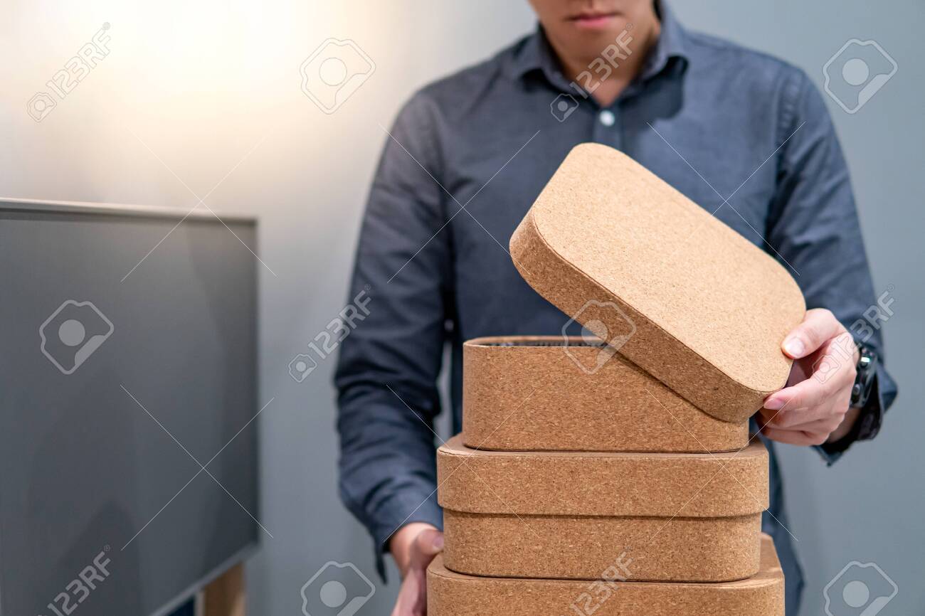 Male Hand Opening Box Lid While Holding Group Of Cork Board Boxes