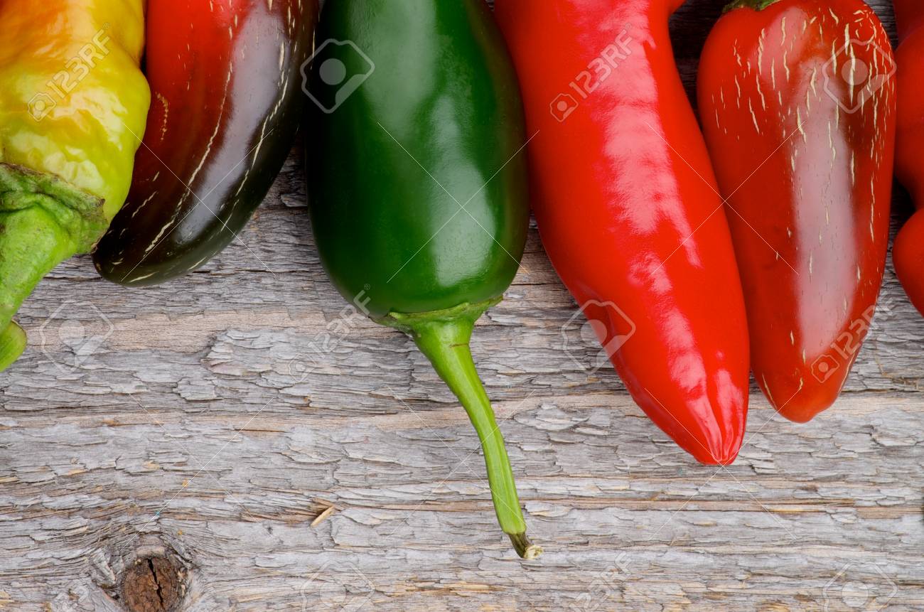 枠の赤と緑ハバネロとハラペーニョ唐辛子素朴な木製の背景に分離 の写真素材 画像素材 Image