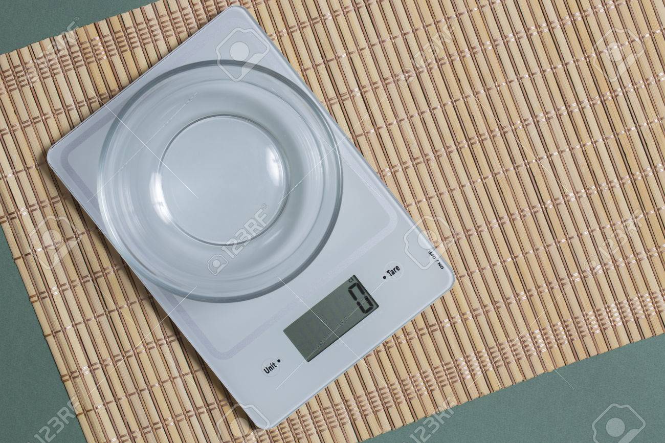 Digital Kitchen Scale With Empty Glass Bowl On Bamboo Mat And