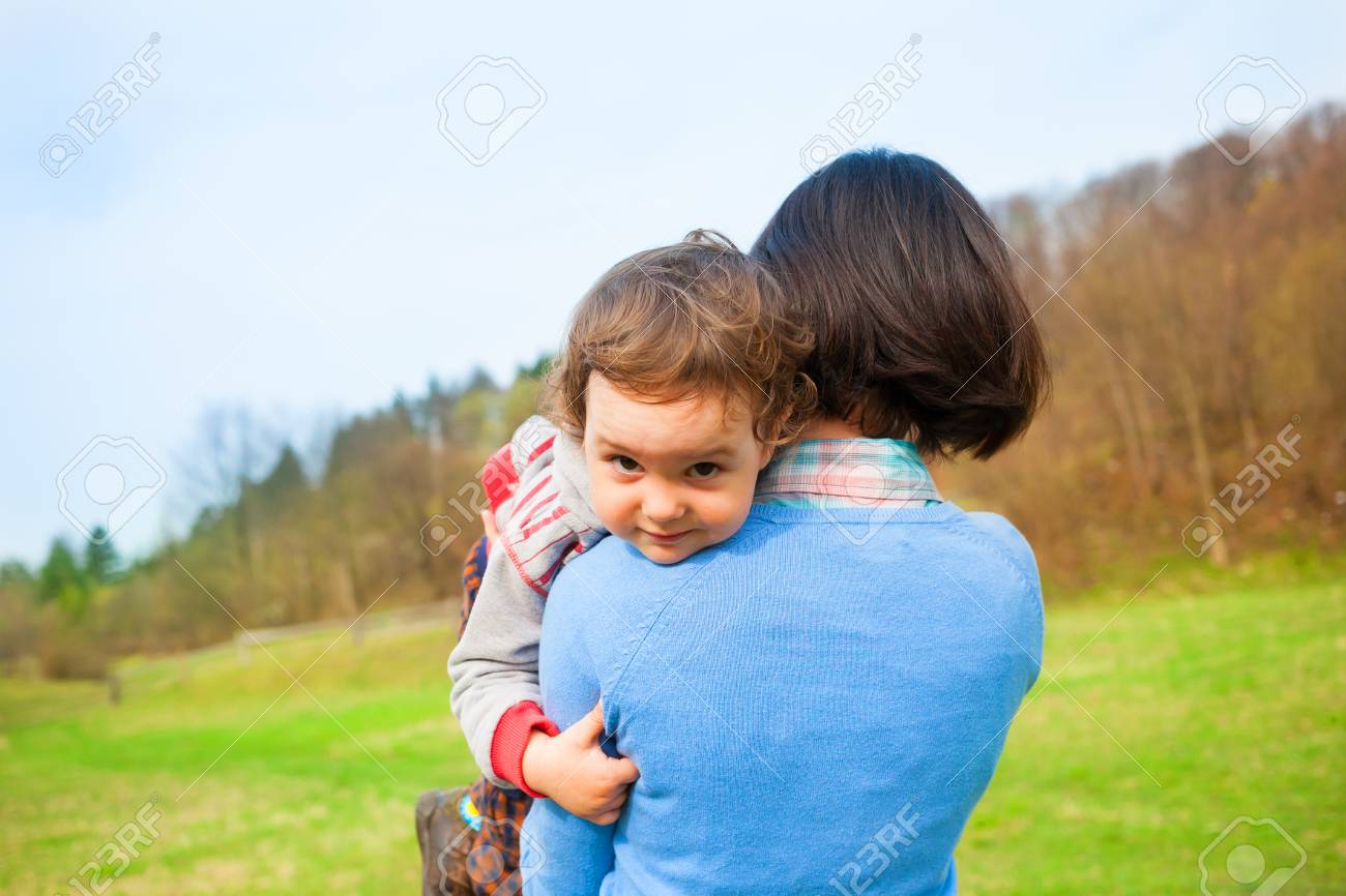 La Mere Porte L Enfant Dans Ses Bras Le Bebe Se Trouve Dans L Epaule De Sa Mere Sur Un Fond De Champ Vert Banque D Images Et Photos Libres De Droits Image