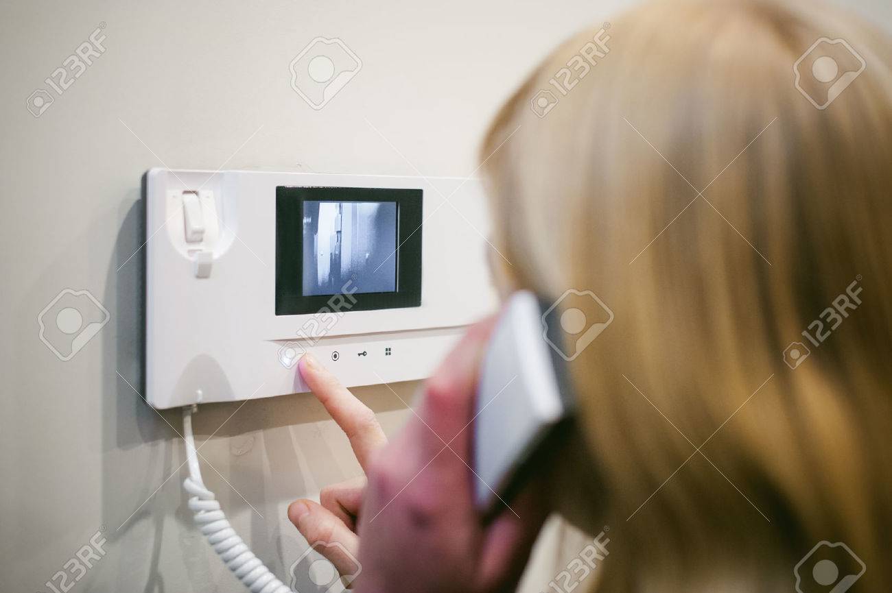 blonde woman answers the intercom call while holding the phone to your ear - 71158836 blonde woman answers the intercom call while holding the phone to your ear - 71158836