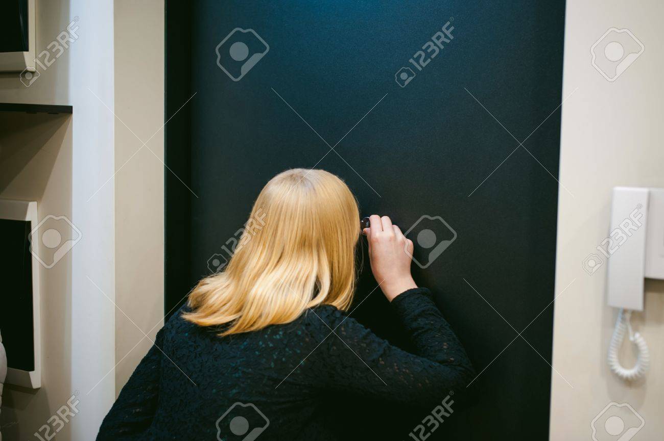 blonde woman looks through the peephole while in his apartment, waiting for the arrival of guests - 70949705 blonde woman looks through the peephole while in his apartment, waiting for the arrival of guests - 70949705