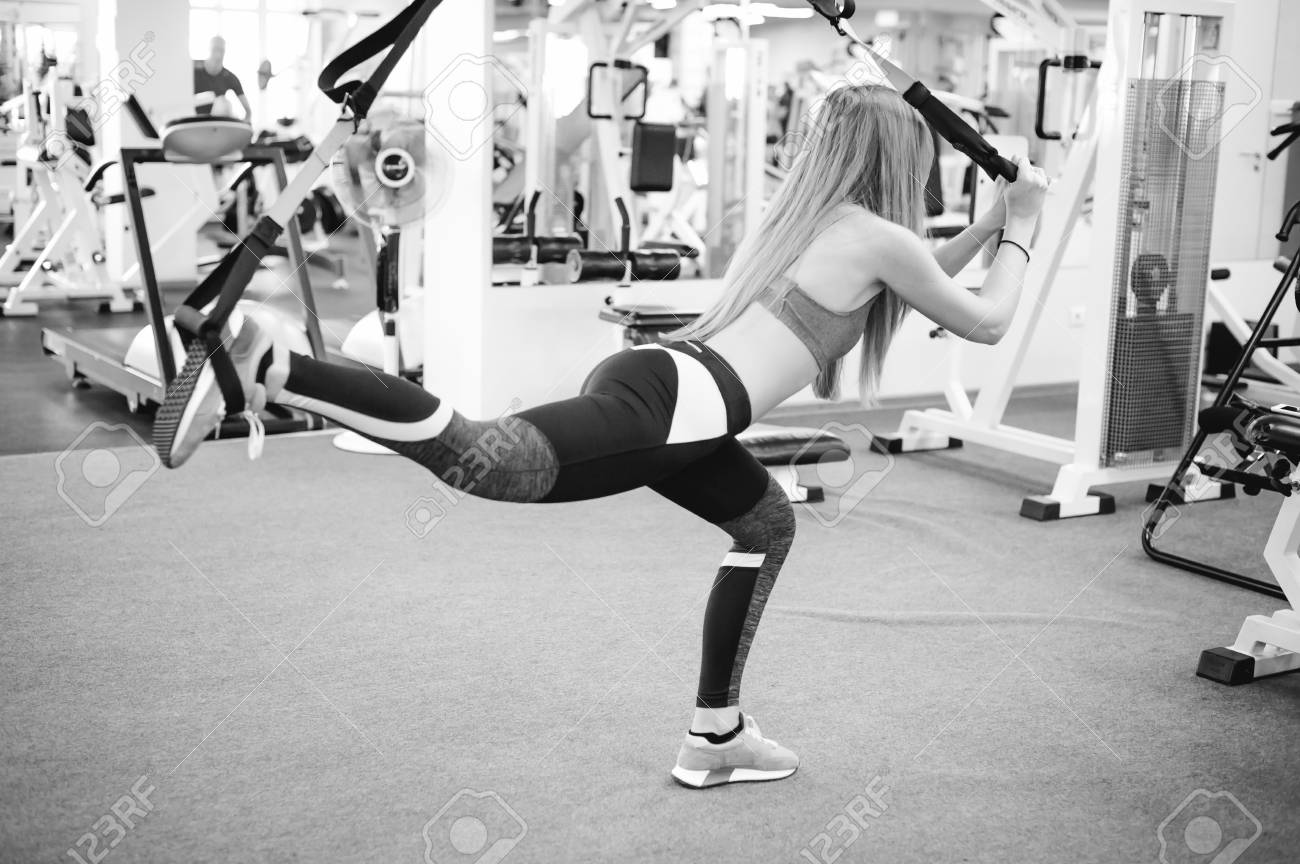 아름 다운 체육 여자 Trx 시스템과 운동을 하 고입니다. 체육관에서 서 스 펜 션 트레이너와 운동하는 젊은 여자. 로열티 무료 사진,  그림, 이미지 그리고 스톡포토그래피. Image 76475565