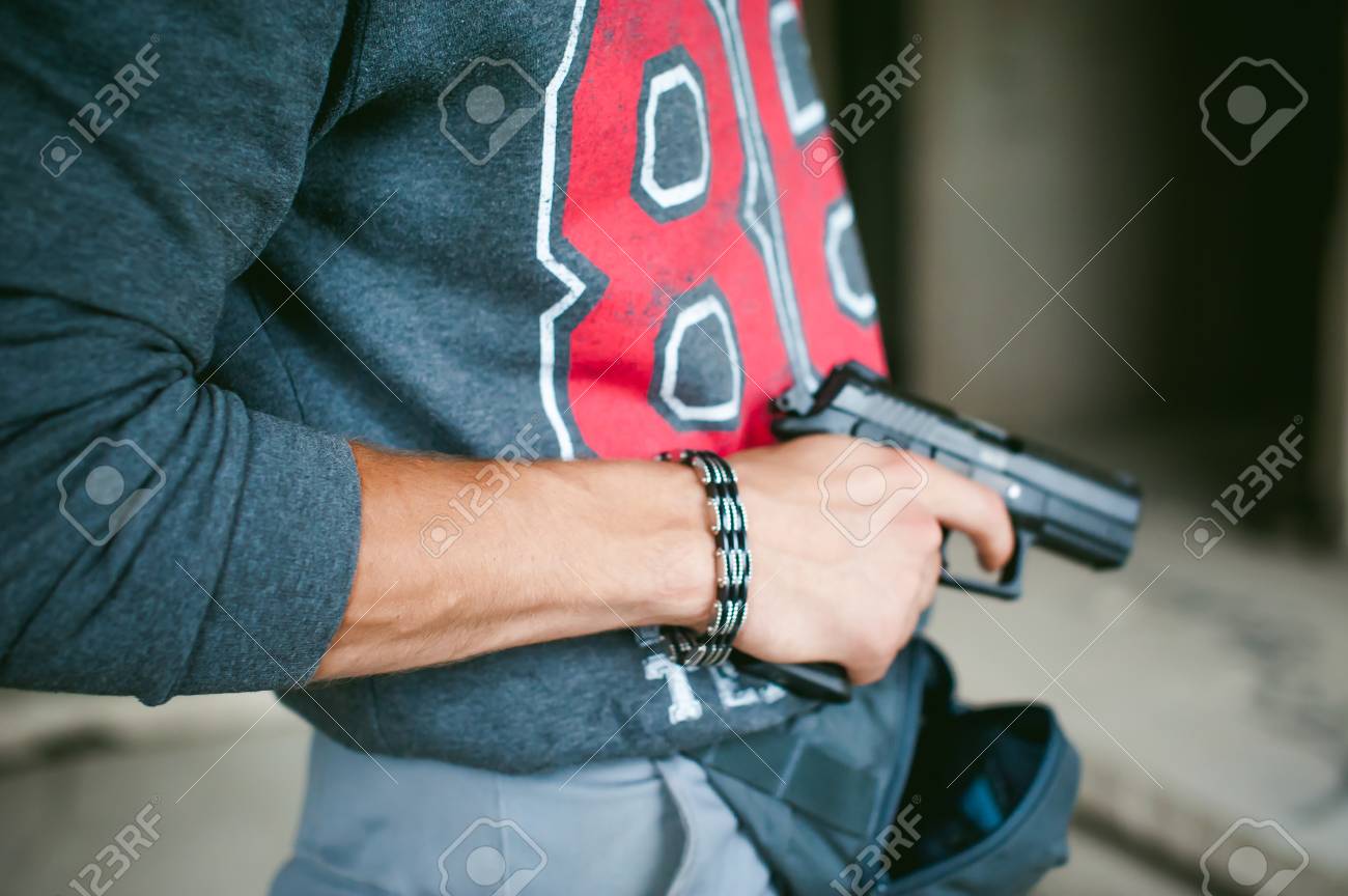O Homem Tira Uma Arma Da Bolsa Segurando A Na Mao Fotos Retratos Imagenes Y Fotografia De Archivo Libres De Derecho Image 83786208