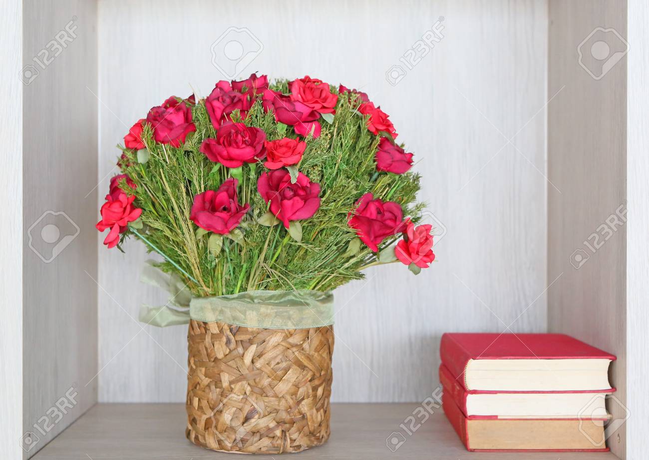 Bouquet Of Artificial Red Roses In Recycle Vase And Books Stock