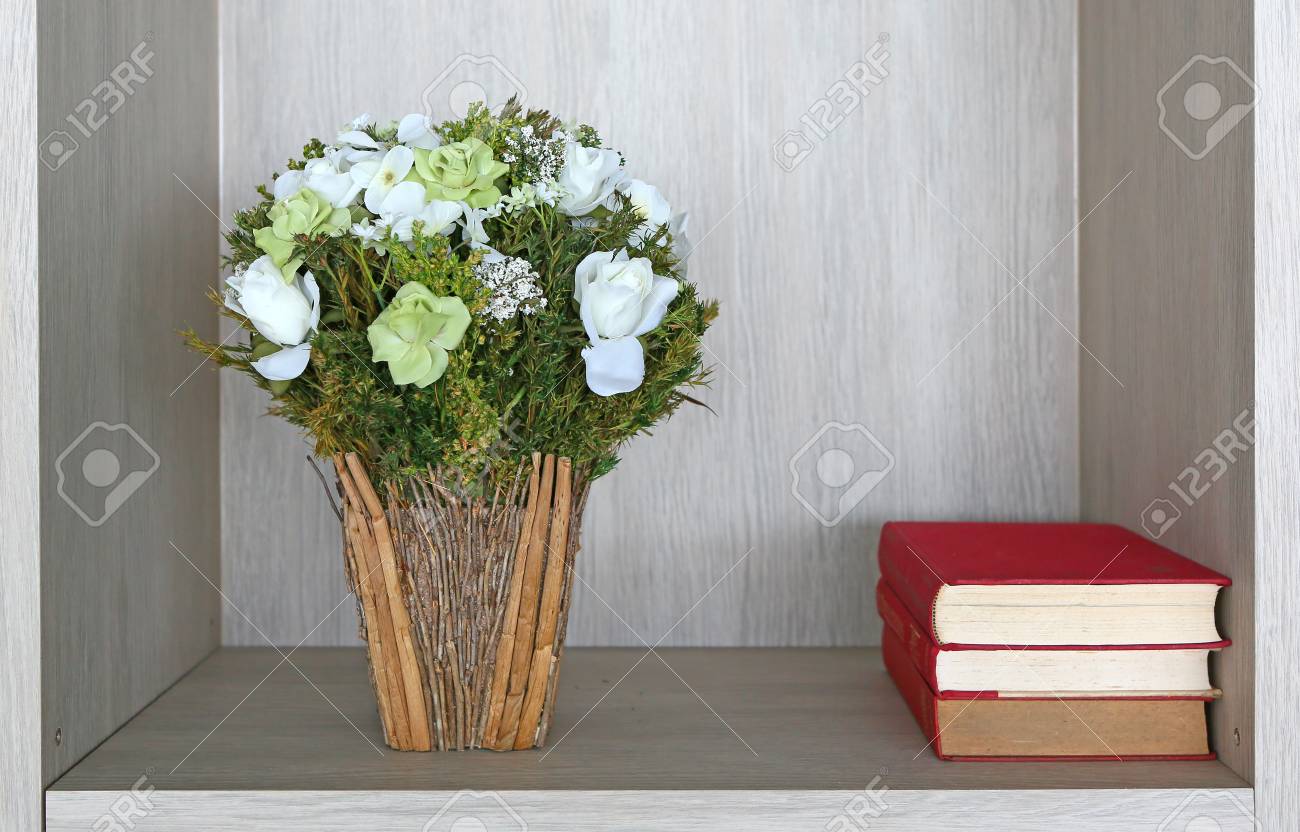 Bouquet Of Artificial Red Roses In Recycle Vase And Books Stock