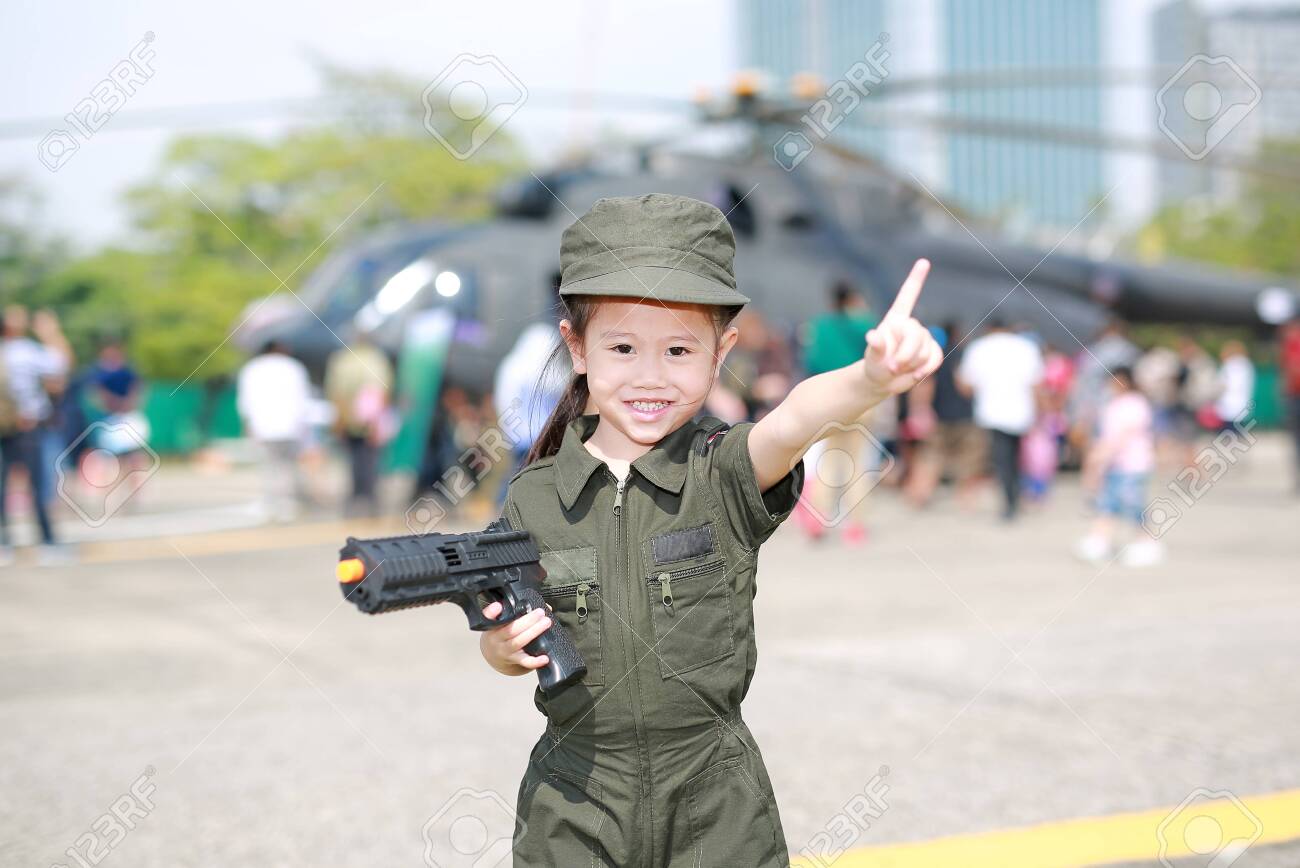 Little Asian child girl in pilot soldier suit costume with holding..