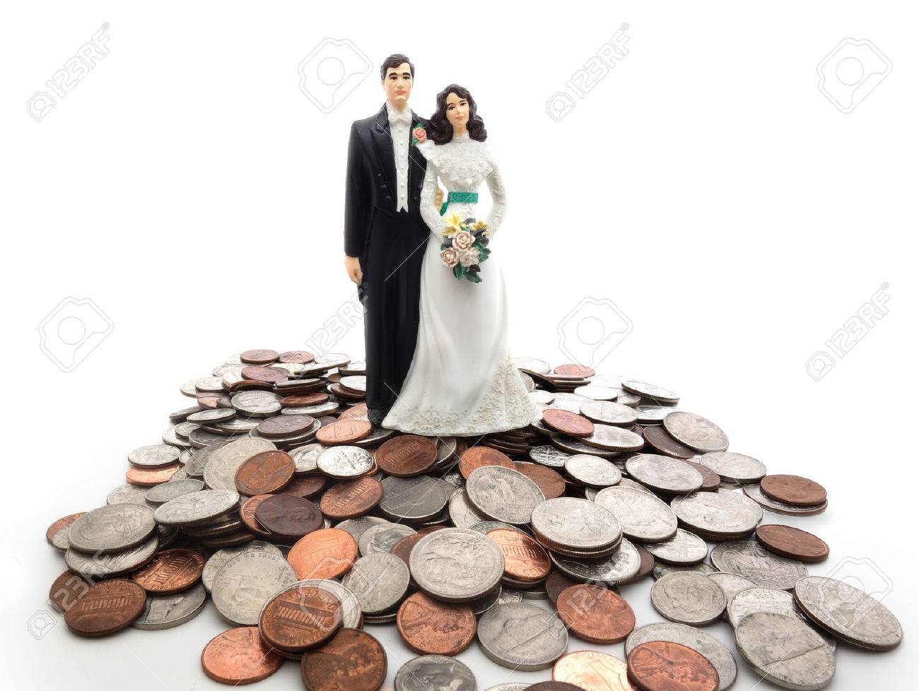 Plastic wedding couple on a pile of coins - money concept - 27699301 Plastic wedding couple on a pile of coins - money concept - 27699301