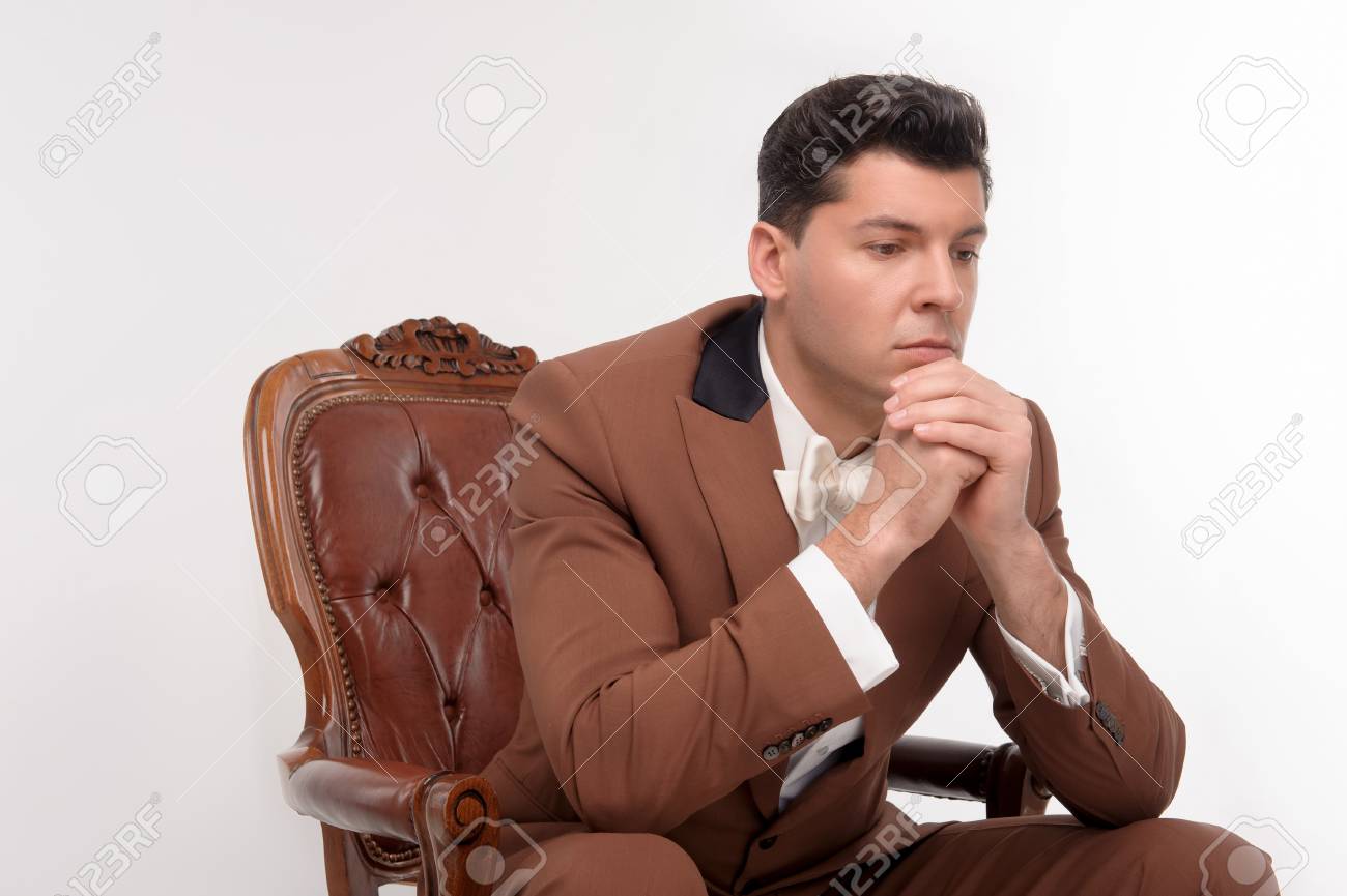 Jeune Homme Serieux Attrayante En Costume Brun Assis Dans Un Fauteuil Isole Sur Fond Blanc Banque D Images Et Photos Libres De Droits Image 29328993