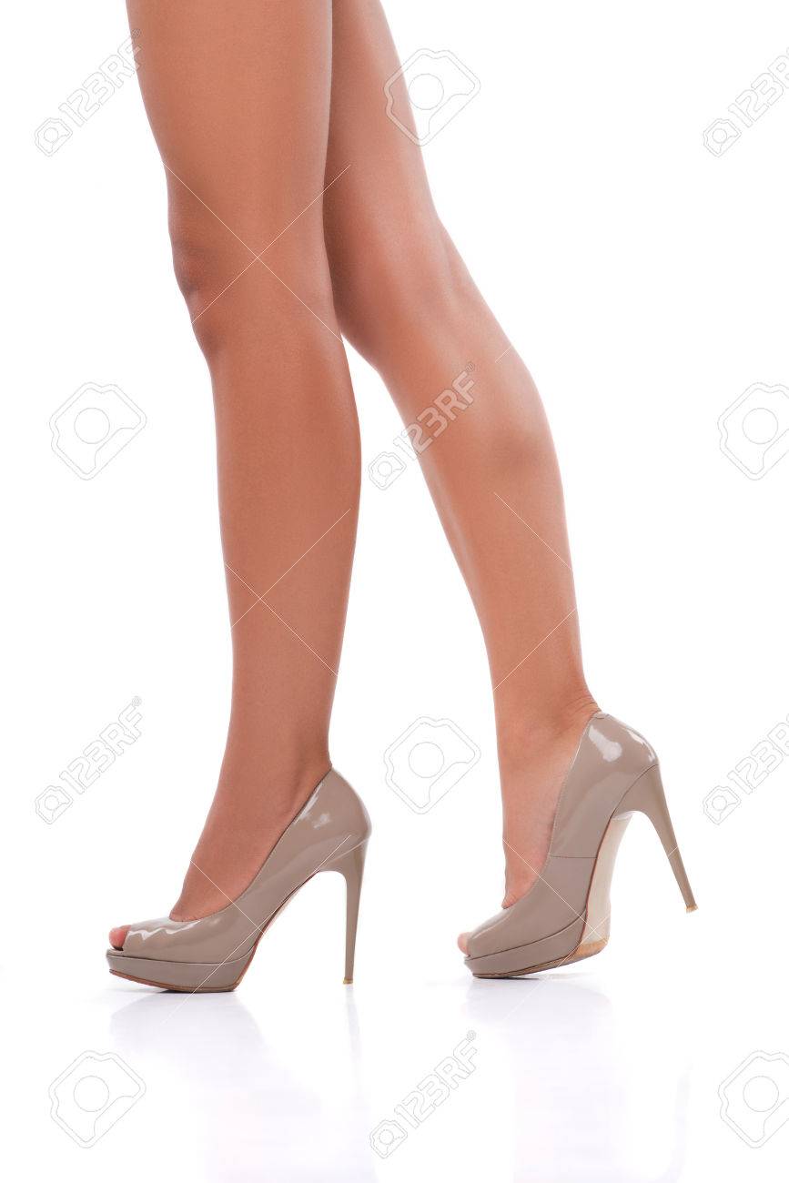 Perfect female legs wearing grey high heels isolated on white.. Perfect female legs wearing high heels isolated on white