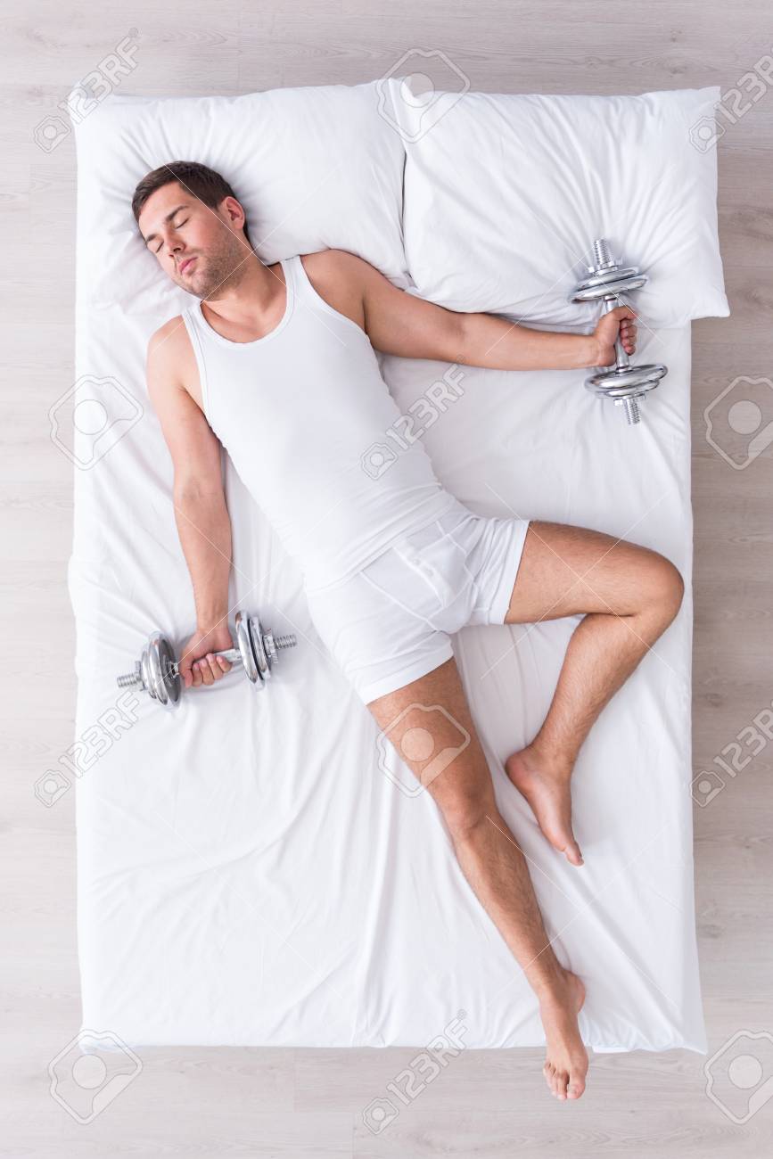 Strong Man Flat Lay Of Relaxed Young Man Sleeping On His Back On White Bed Dreaming About Muscular Body Holding Dumbbells In Hands Stock Photo Picture And Royalty Free Image Image 62888248