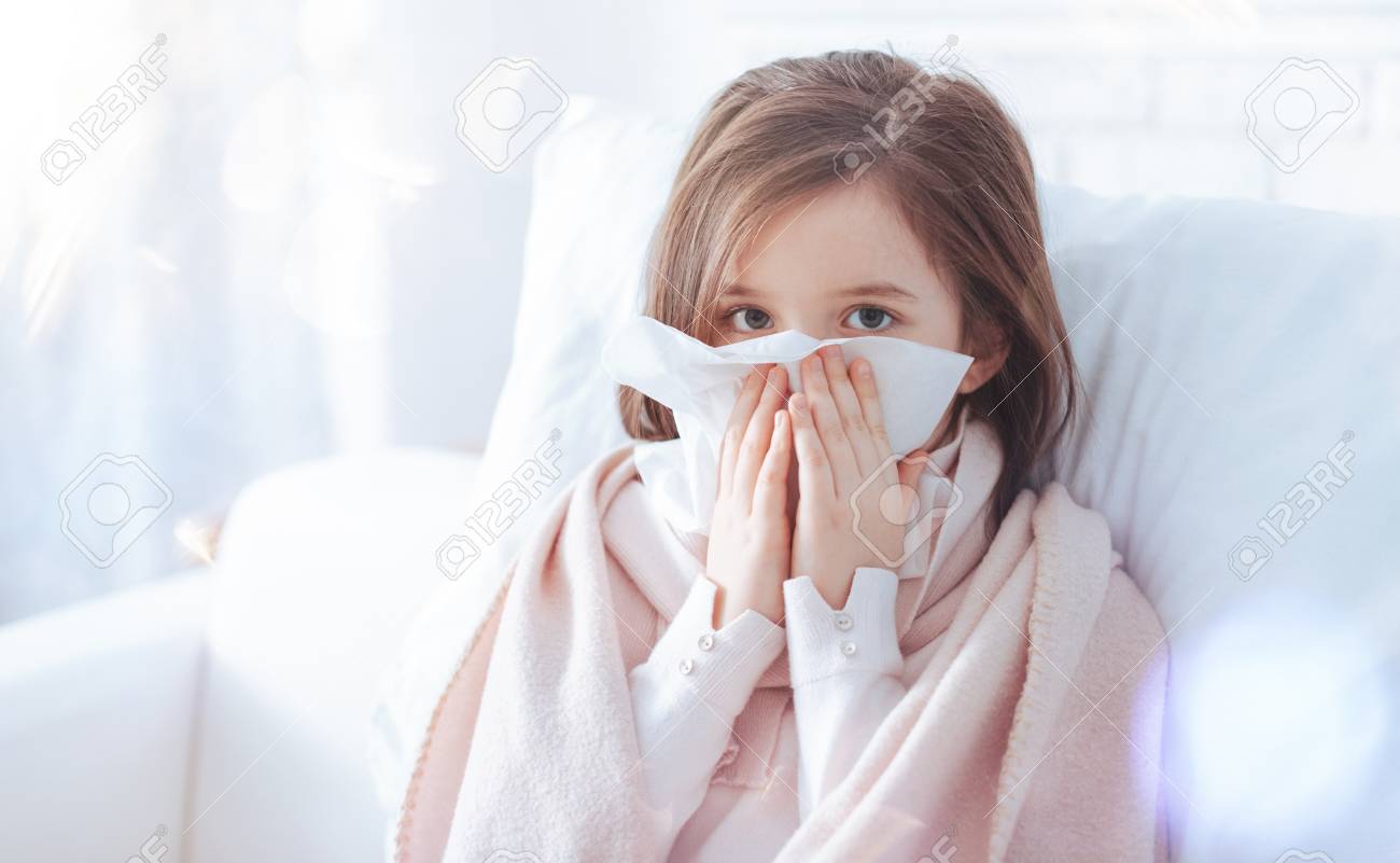 blow your nose pretty child sitting on white furniture and keeping