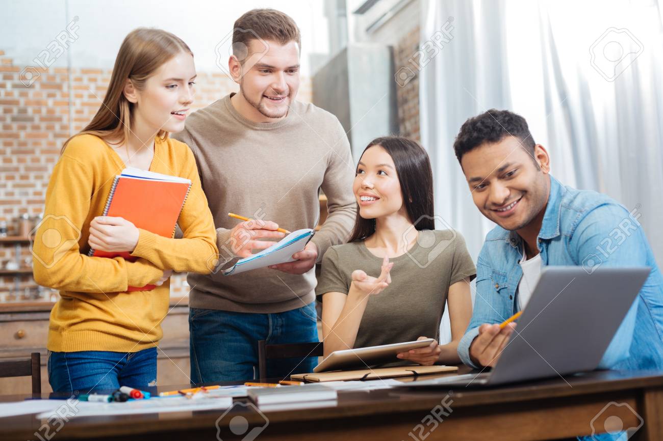 Friendly Students. Cheerful Pleasant Young People Feeling Happy While  Sitting Together And Working At Their Project For The Next Lesson Stock  Photo, Picture and Royalty Free Image. Image 93227059., image size:1300x866