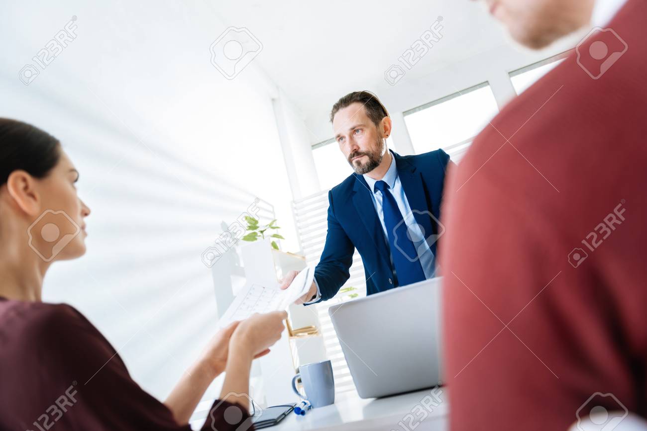 ちょっと待ってください 立って手を伸ばす上司に彼女のレポートを扱う魅力的なかわいい女性従業員 の写真素材 画像素材 Image