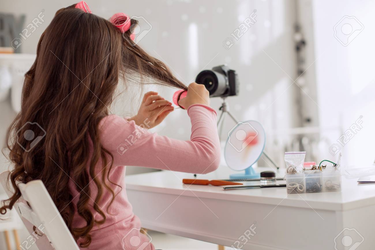 素敵なヘアスタイル 魅力的な10代前の女の子は ビデオチュートリアルを記録し ヘアローラーを正しく使用する方法を示し 彼らと彼女の髪のロックをカール の写真素材 画像素材 Image