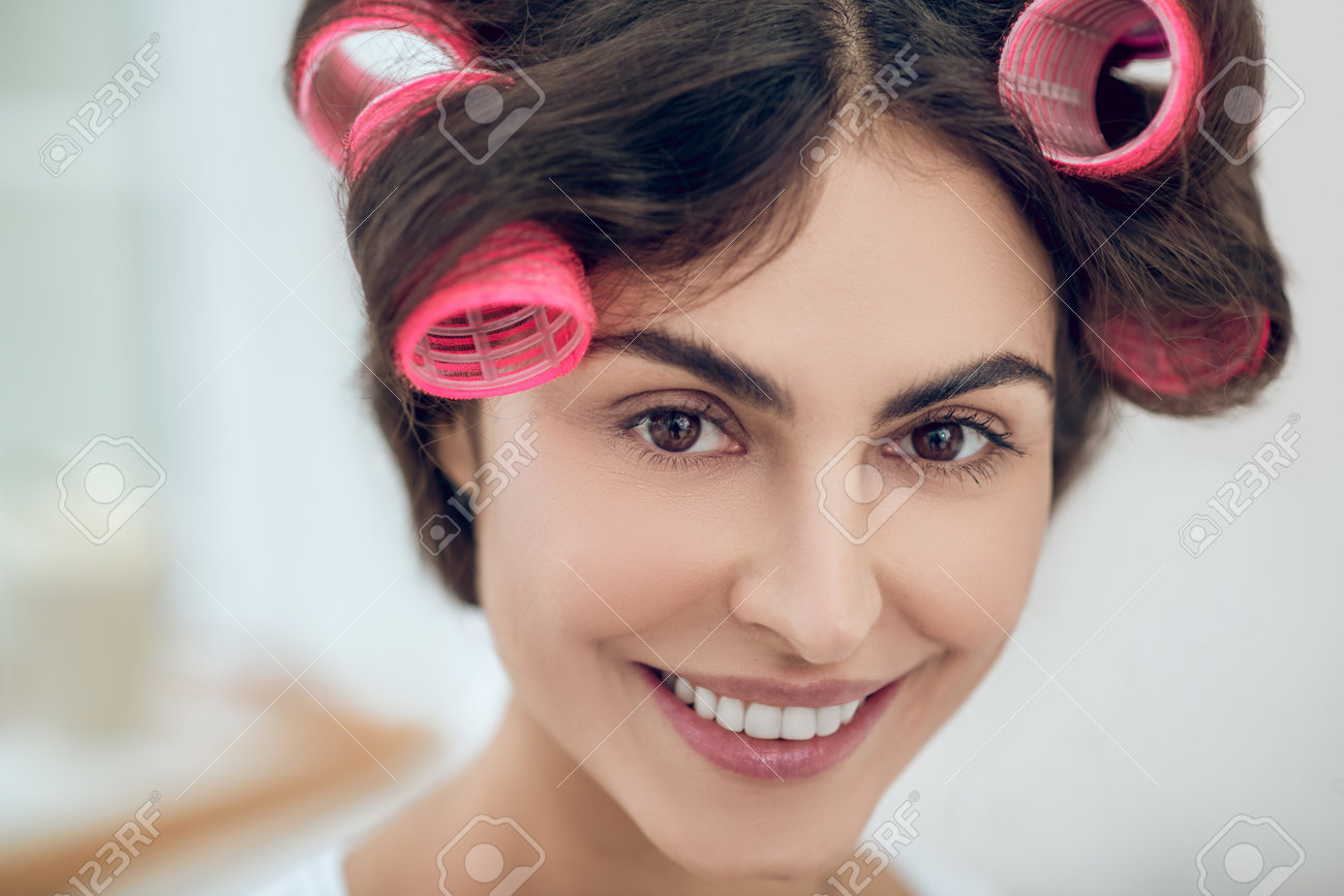 Close-up face of beautiful young woman in hair curlers - 166230352 Close-up face of beautiful young woman in hair curlers - 166230352