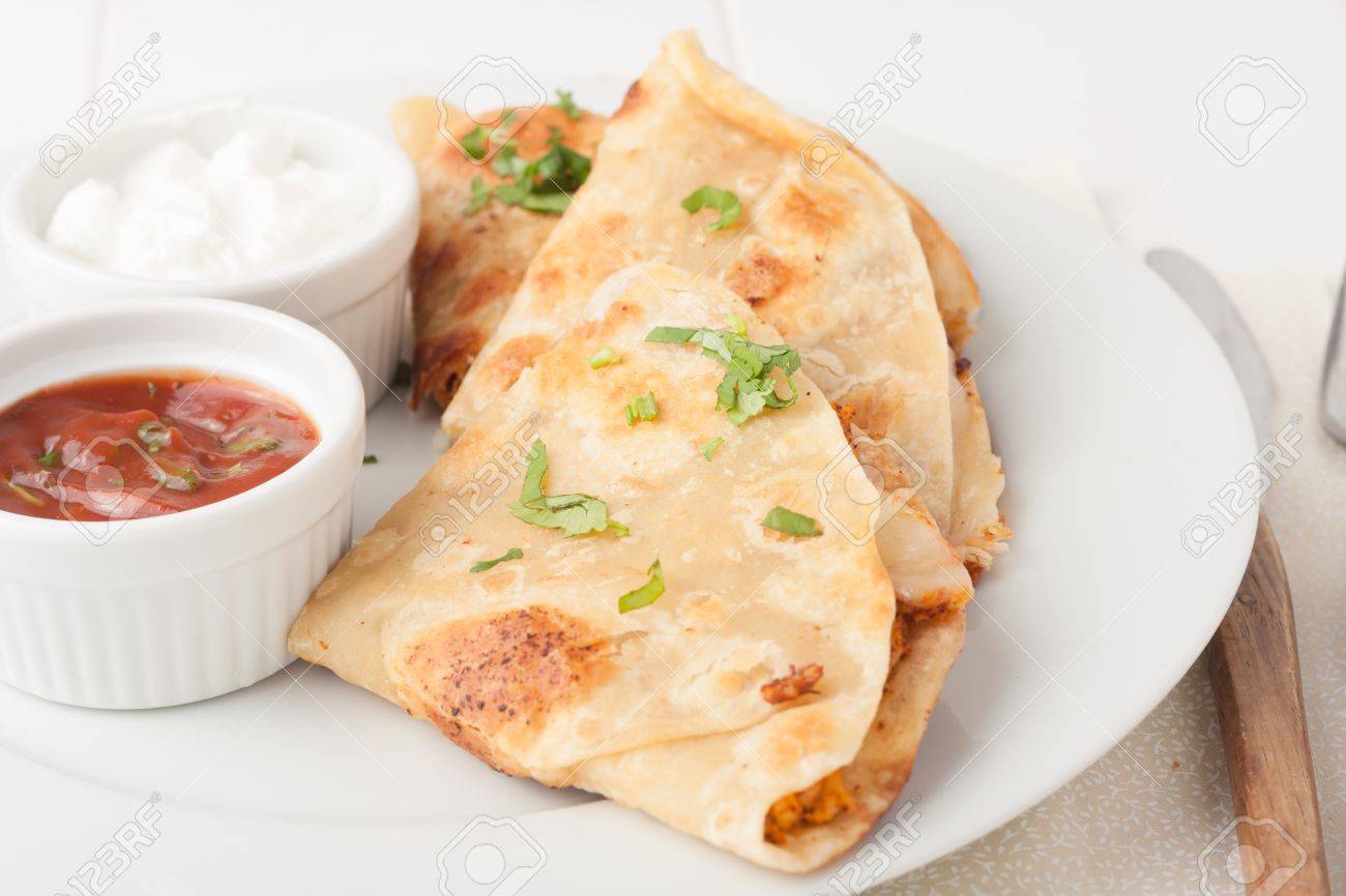 original mexican quesadilla garnished with cilantro on white plate with sour cream and salsa - 37708218 original mexican quesadilla garnished with cilantro on white plate with sour cream and salsa - 37708218