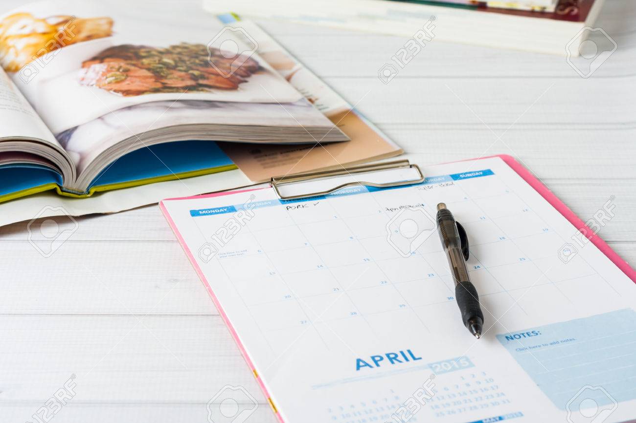 Monthly calendar and stack of cookbooks. Conceptual image showing meal planning in progress. Shallow depth of field - 38574514 Monthly calendar and stack of cookbooks. Conceptual image showing meal planning in progress. Shallow depth of field - 38574514