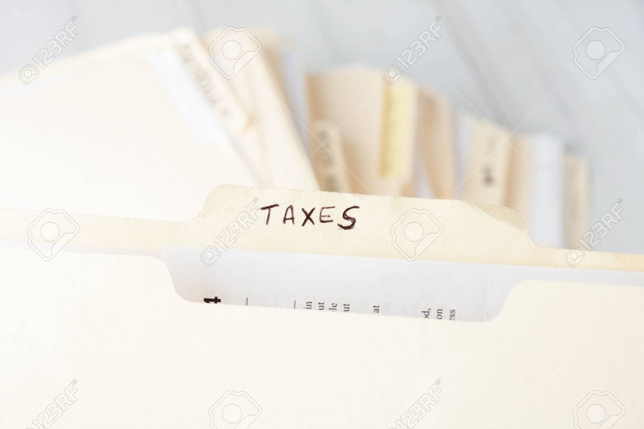 yellow paper folder labeled TAXES containing tax documents of a small business firm - 38981553 yellow paper folder labeled TAXES containing tax documents of a small business firm - 38981553