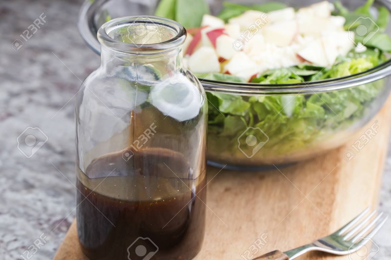 a glass bottle with salad dressing consisting of balsamic vinegar, honey and olive oil and spices - 71241292 a glass bottle with salad dressing consisting of balsamic vinegar, honey and olive oil and spices - 71241292