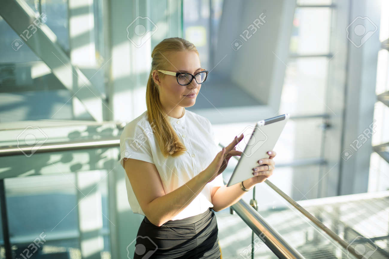 Trabalhador inteligente do governo da mulher que usa aplicações através da almofada do toque quando está no interior moderno do escritório. candidato orgulhoso fêmea que procura a informação através do gadget digital que está dentro da empresa - 159452680 Trabalhador inteligente do governo da mulher que usa aplicações através da almofada do toque quando está no interior moderno do escritório. candidato orgulhoso fêmea que procura a informação através do gadget digital que está dentro da empresa - 159452680