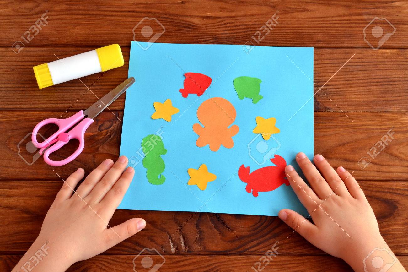 海の動物や魚とカード キッズ クラフト アイデア プロジェクト 接着剤 ハサミ 子供がテーブルの上に手を置く の写真素材 画像素材 Image