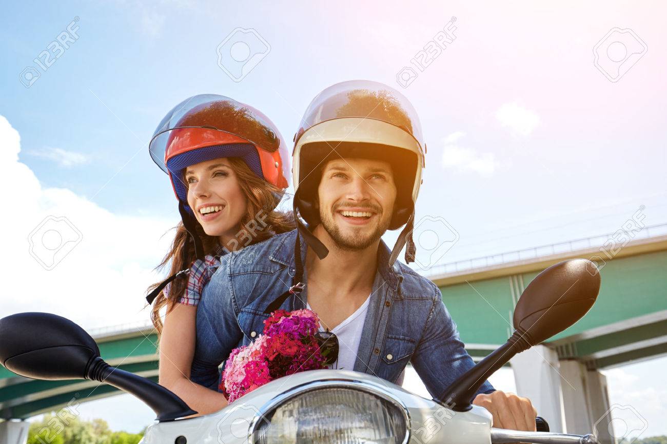 Cheerful couple riding vintage scooter - 54366986 Cheerful couple riding vintage scooter - 54366986