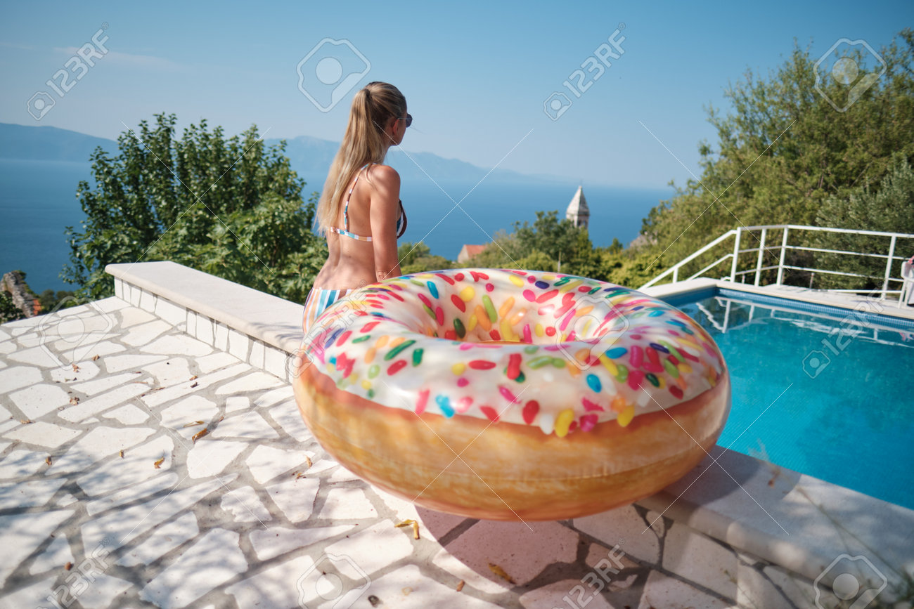 Holiday resort in Croatia. Woman next to swimming pool with sea view. Vacation relax. Sea with mountains at background - 162108073 Holiday resort in Croatia. Woman next to swimming pool with sea view. Vacation relax. Sea with mountains at background - 162108073