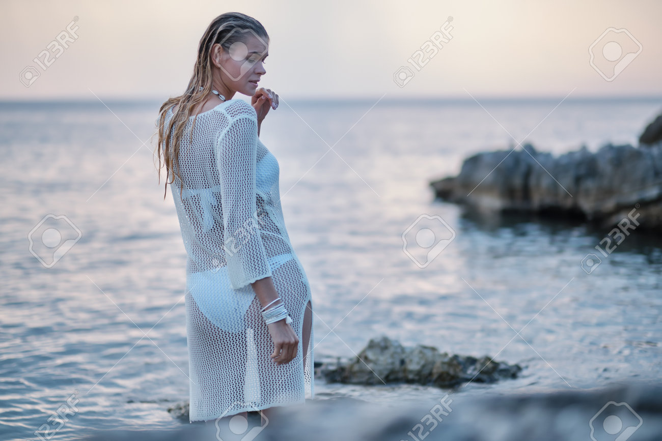 A woman on a rocky beach in Croatia. - 162108027 A woman on a rocky beach in Croatia. - 162108027