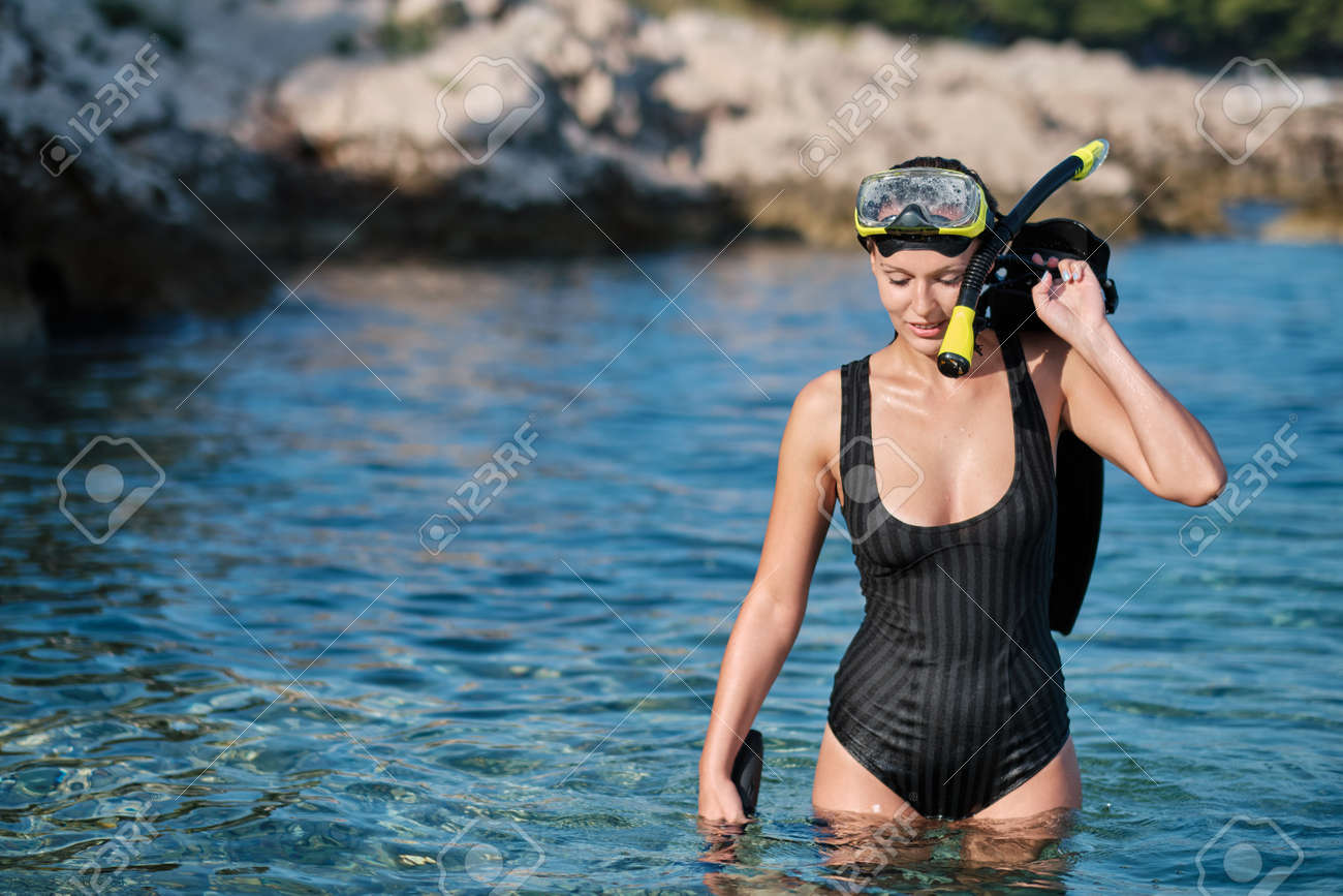 A woman in a bikini hunts with a crossbow - 163582301 A woman in a bikini hunts with a crossbow - 163582301