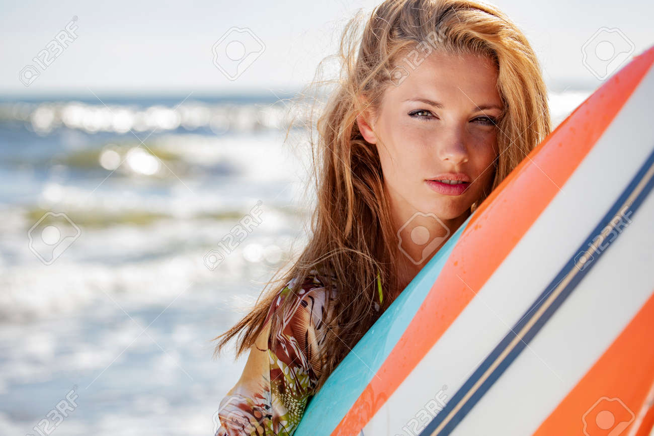 Beautiful female surfer with surfboard on a summer day. - 168625988 Beautiful female surfer with surfboard on a summer day. - 168625988