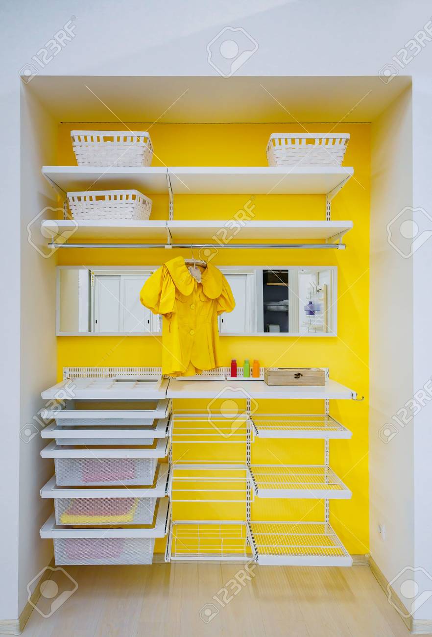 明るい黄色のウォークインクローゼット 洋服と棚 ビン 自宅のボックス の写真素材 画像素材 Image