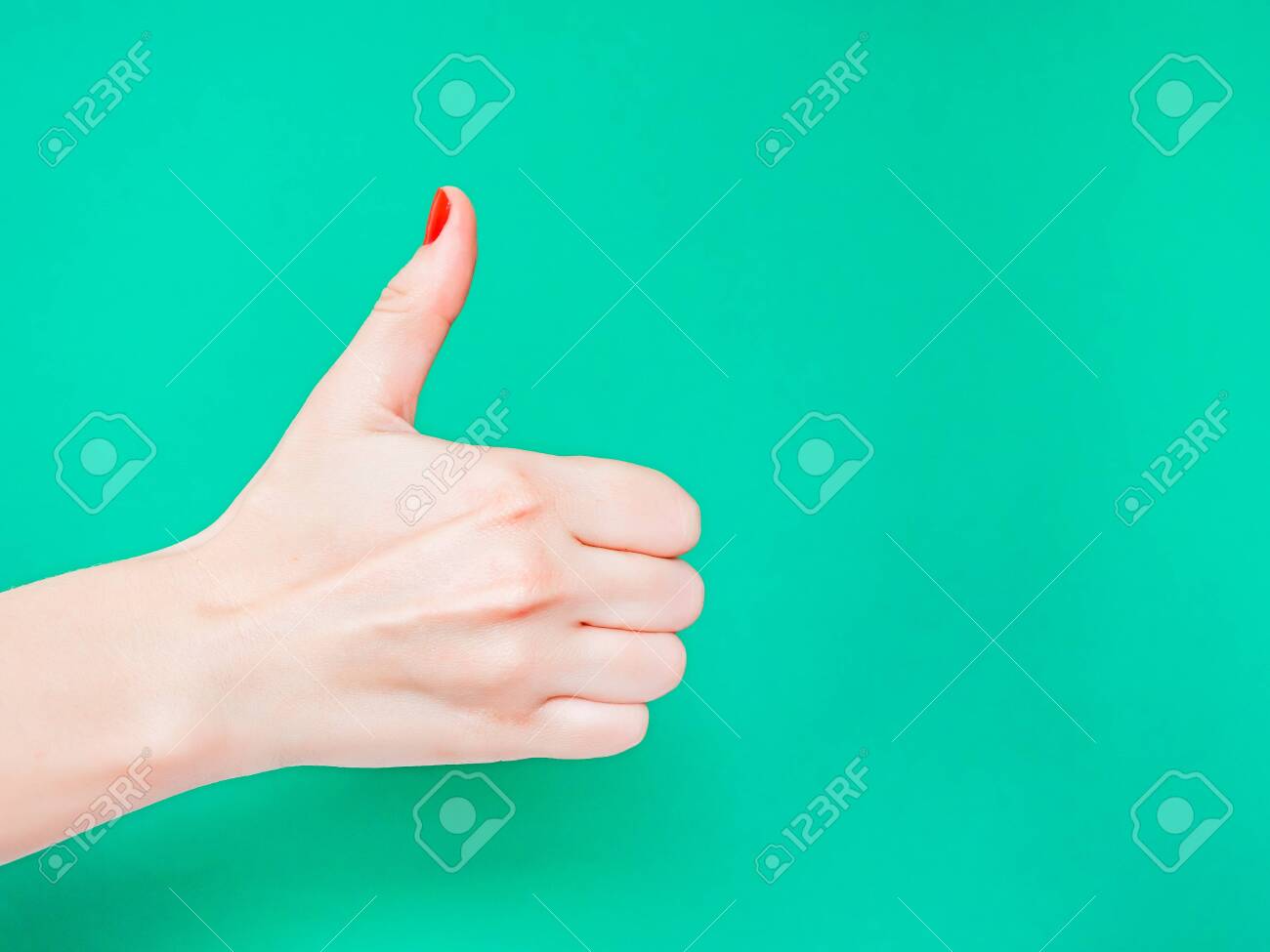 The Thumbs Up Sign. Like Hand Sign. Used when you want to demonstrate that you like something or that you approve of something, The ol thumbs up hand sign. Female hand with red manicure on fingernails holding hand in gesture of likeness giving thumb up on isolated turquoise green color background - 121638490 The Thumbs Up Sign. Like Hand Sign. Used when you want to demonstrate that you like something or that you approve of something, The ol thumbs up hand sign. Female hand with red manicure on fingernails holding hand in gesture of likeness giving thumb up on isolated turquoise green color background - 121638490