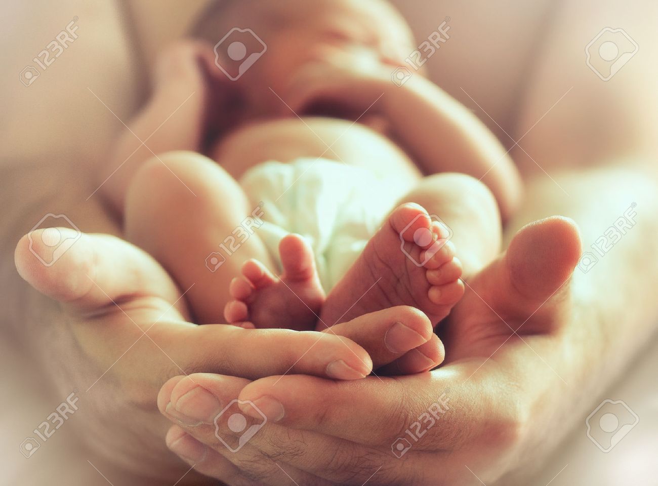 strong male hands holding sleeping newborn baby, photo with soft blur effect - 63734001 strong male hands holding sleeping newborn baby, photo with soft blur effect - 63734001