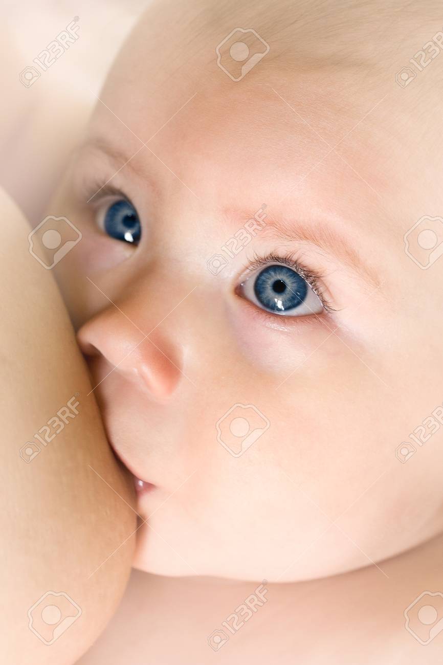 きれいな青い目のクローズ アップと赤ちゃんの授乳 の写真素材 画像素材 Image