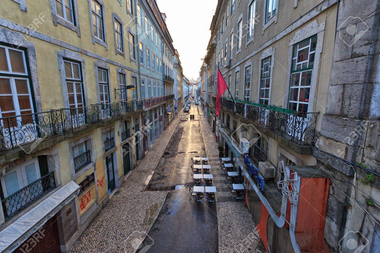 Scene De Rue Dans Le Centre Ville De Lisbonne Avec Une Rue Deserte Courir Entre Les Batiments Historiques De Plusieurs Etages Avec Des Balcons Et Des Magasins De Decoration Au Niveau Du Sol