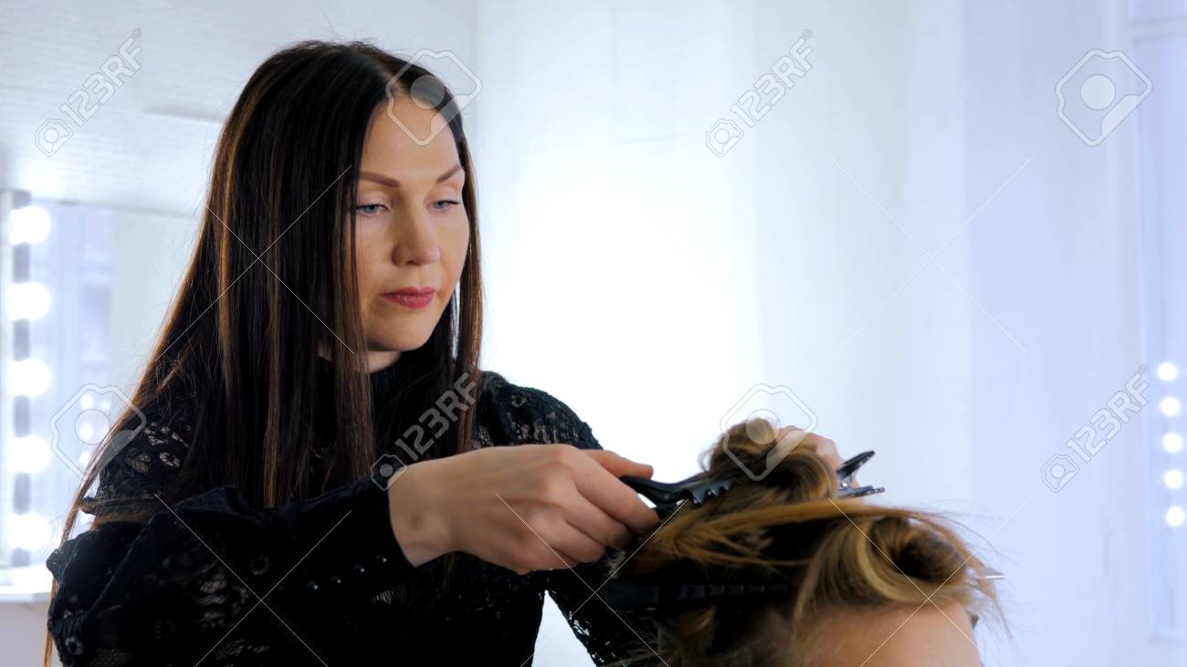 プロの美容師 スタイリストは若いかわいい女性のためのヘアスタイルを プロの美容師 スタイリストは若いかわいい女性のためのヘアスタイルを