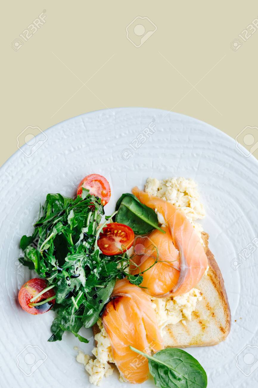 Salted Salmon Scrambled Eggs On Toast With Spinach And Tomato Salad Served On A White Plate Top View Over Beige Background Stock Photo Picture And Royalty Free Image Image