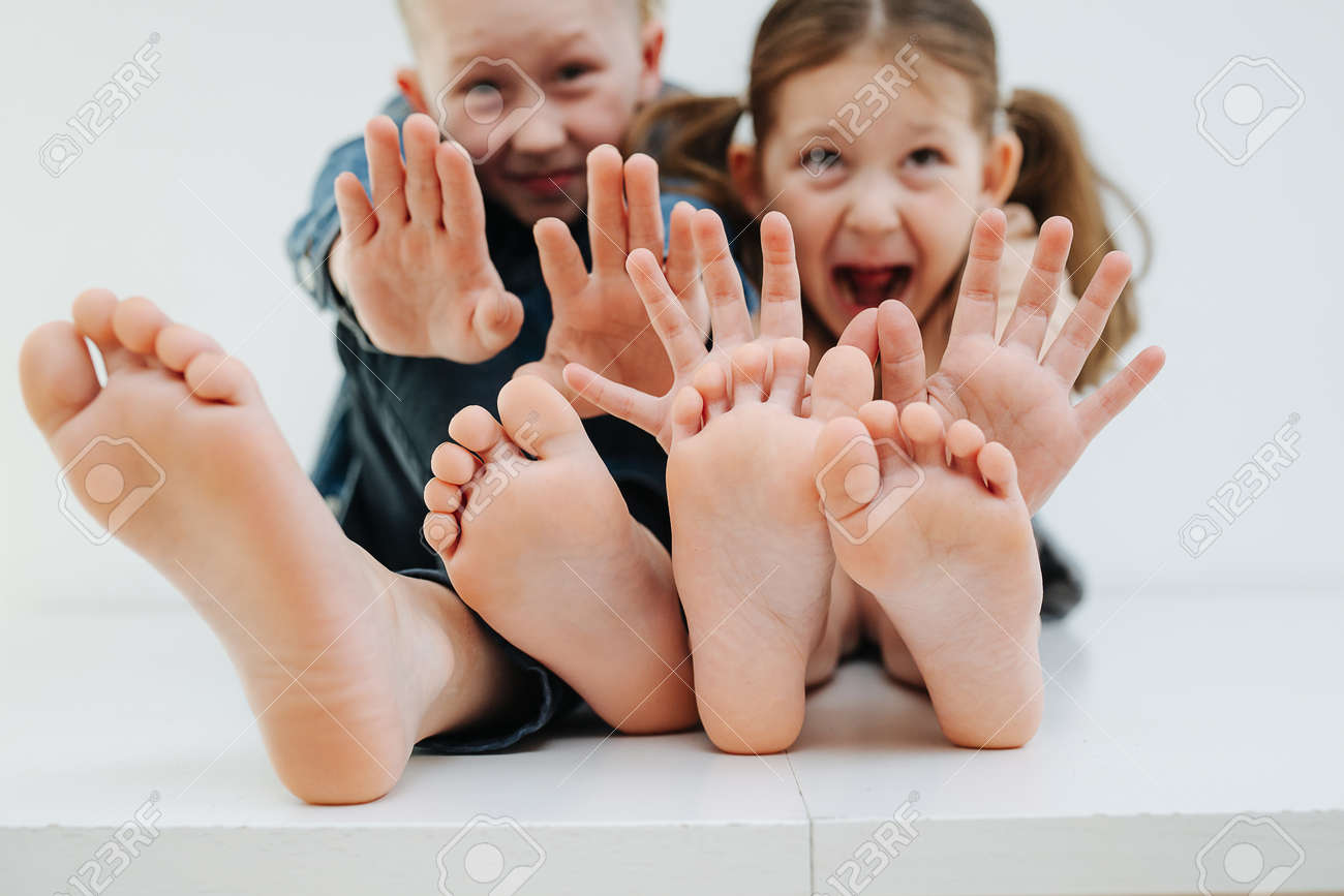 Dont tickle. Little siblings sitting on a table with feet. Stop gesture - 169819602 Dont tickle. Little siblings sitting on a table with feet. Stop gesture - 169819602